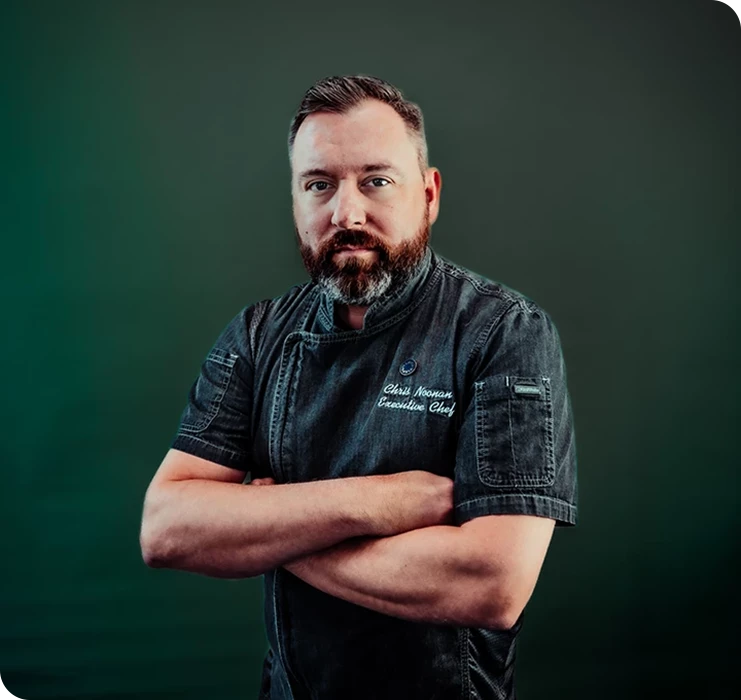 a man with beard and mustache wearing a black apron