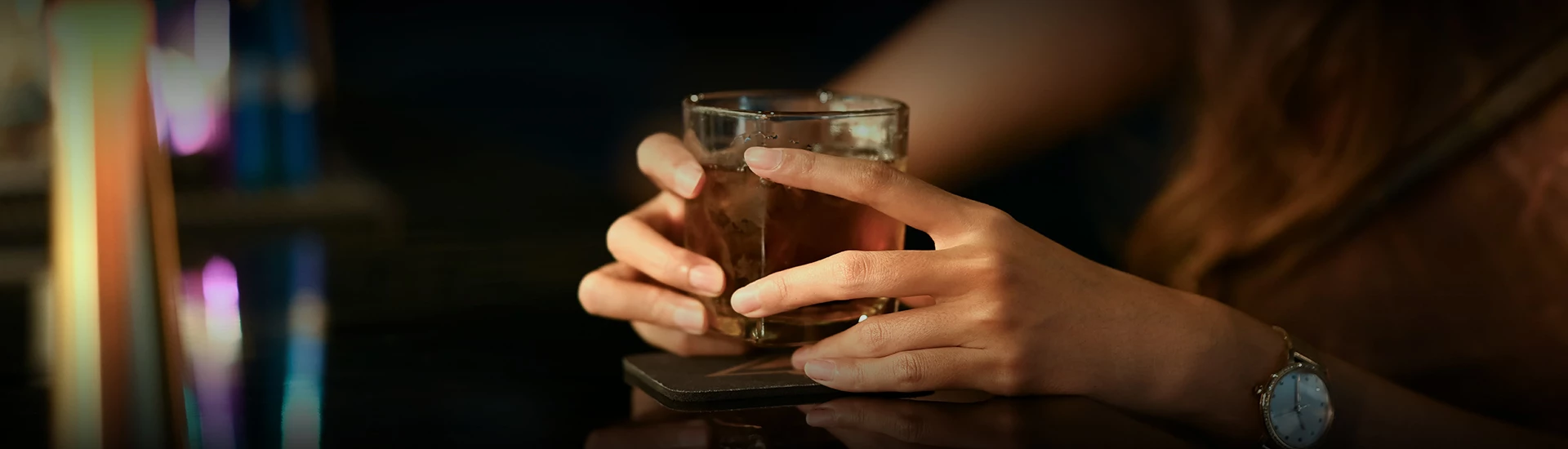 a person holding a glass of liquid
