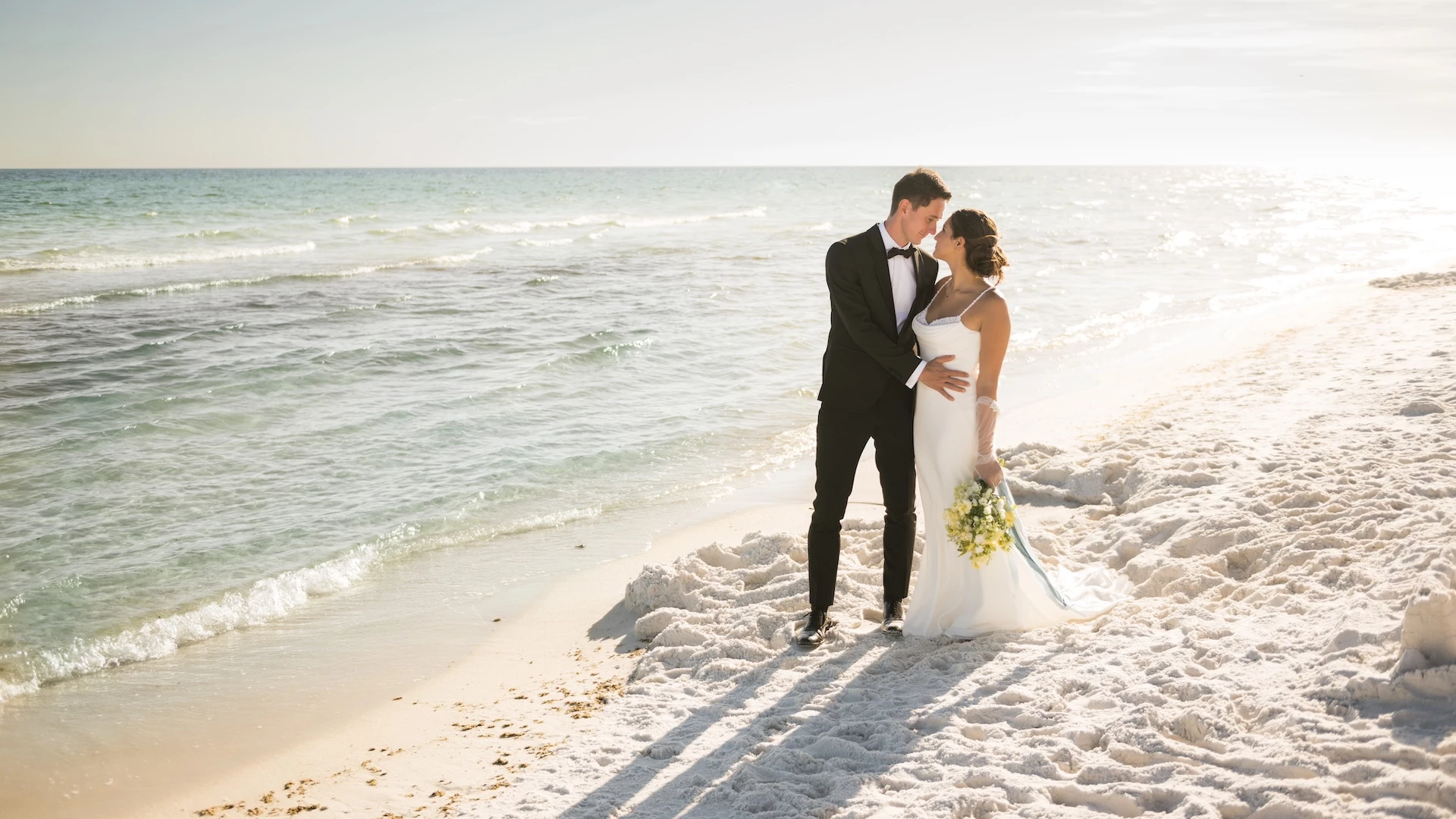 a man and woman kissing on a beach