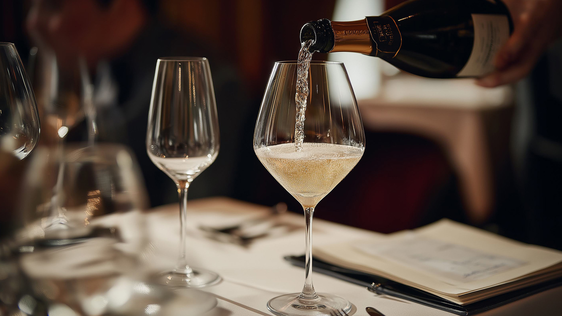 a person pouring a glass of wine