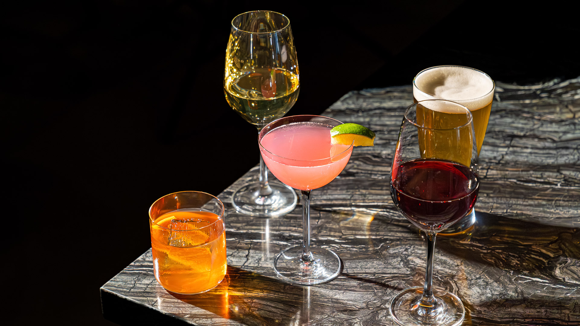 a group of glasses of different colored drinks