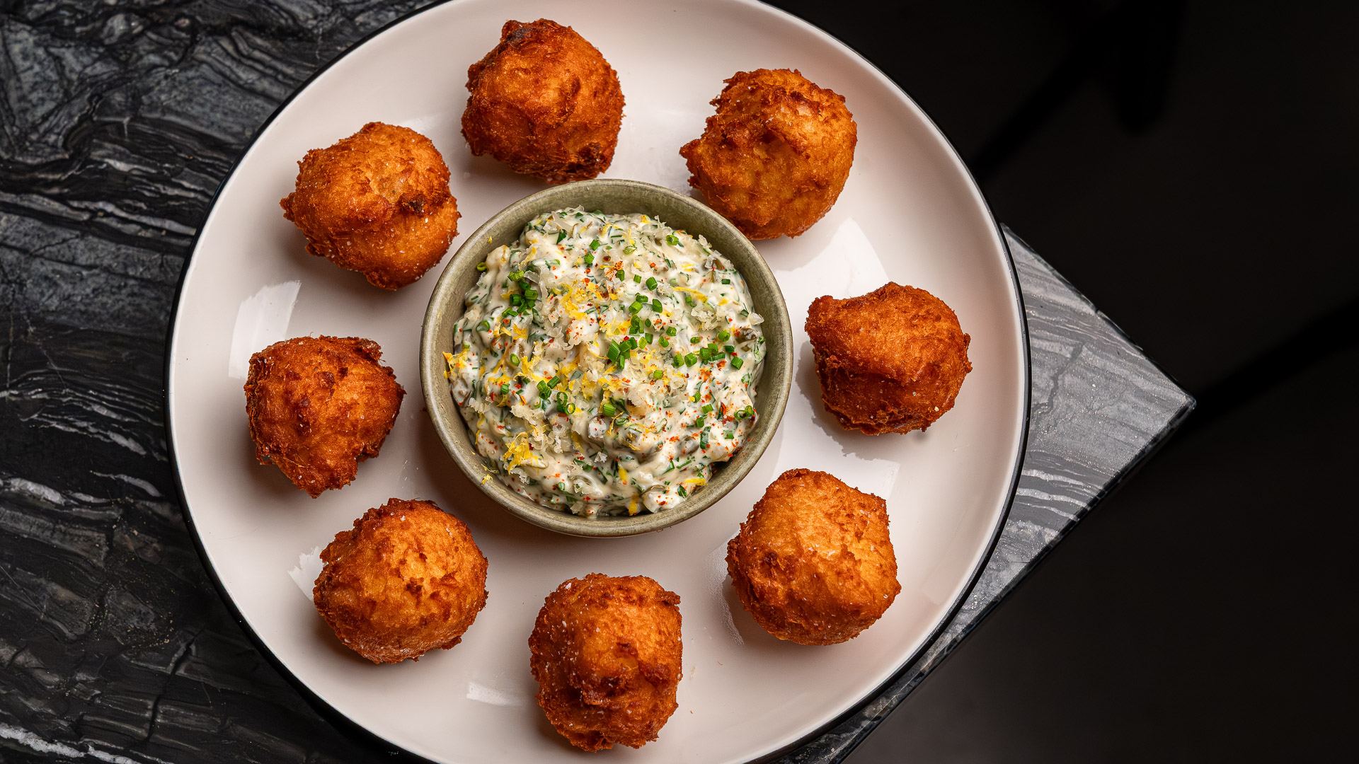 a plate of fried food with a bowl of dip