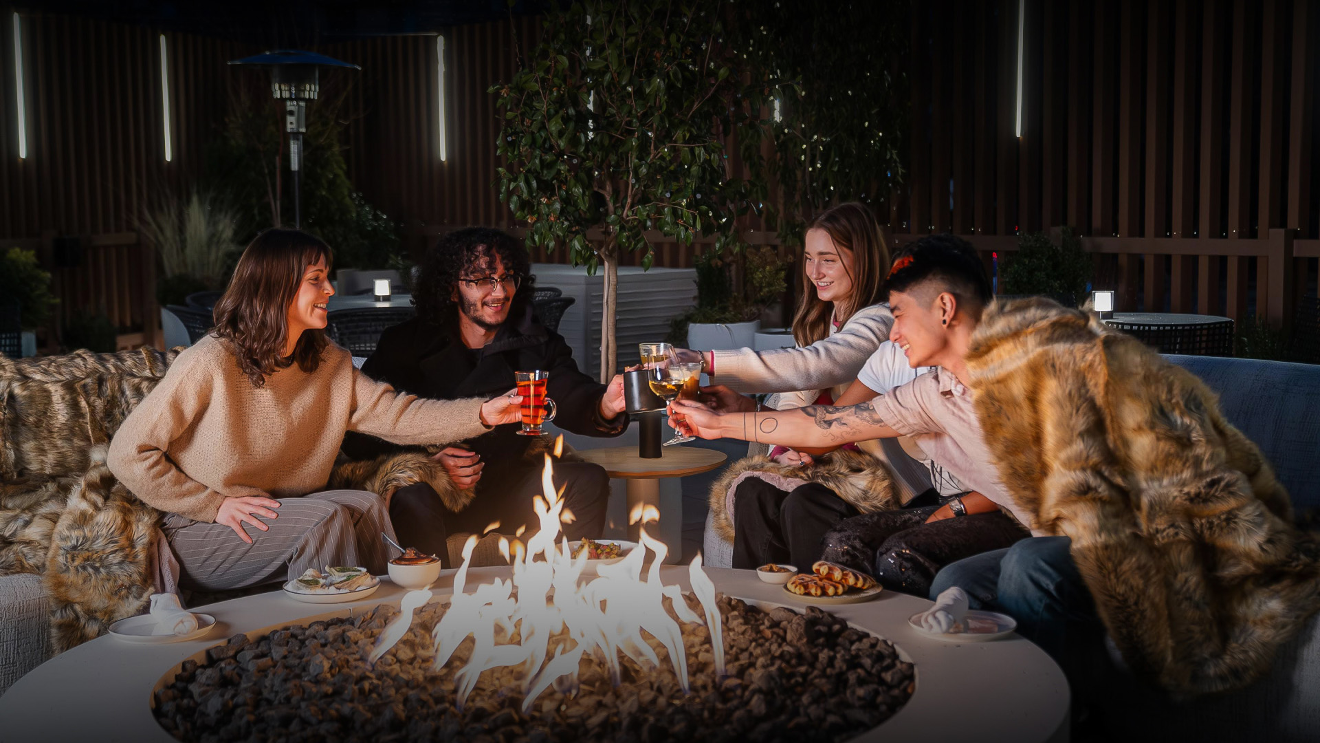 a group of people sitting around a fire pit