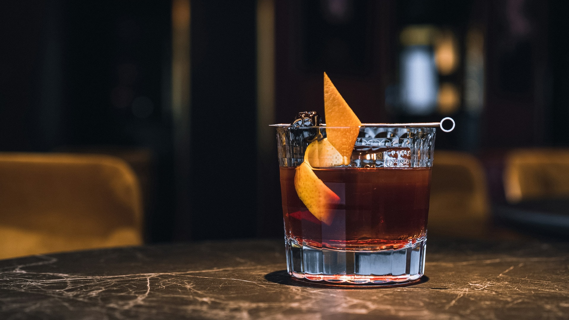 a glass with a drink and a slice of orange on it