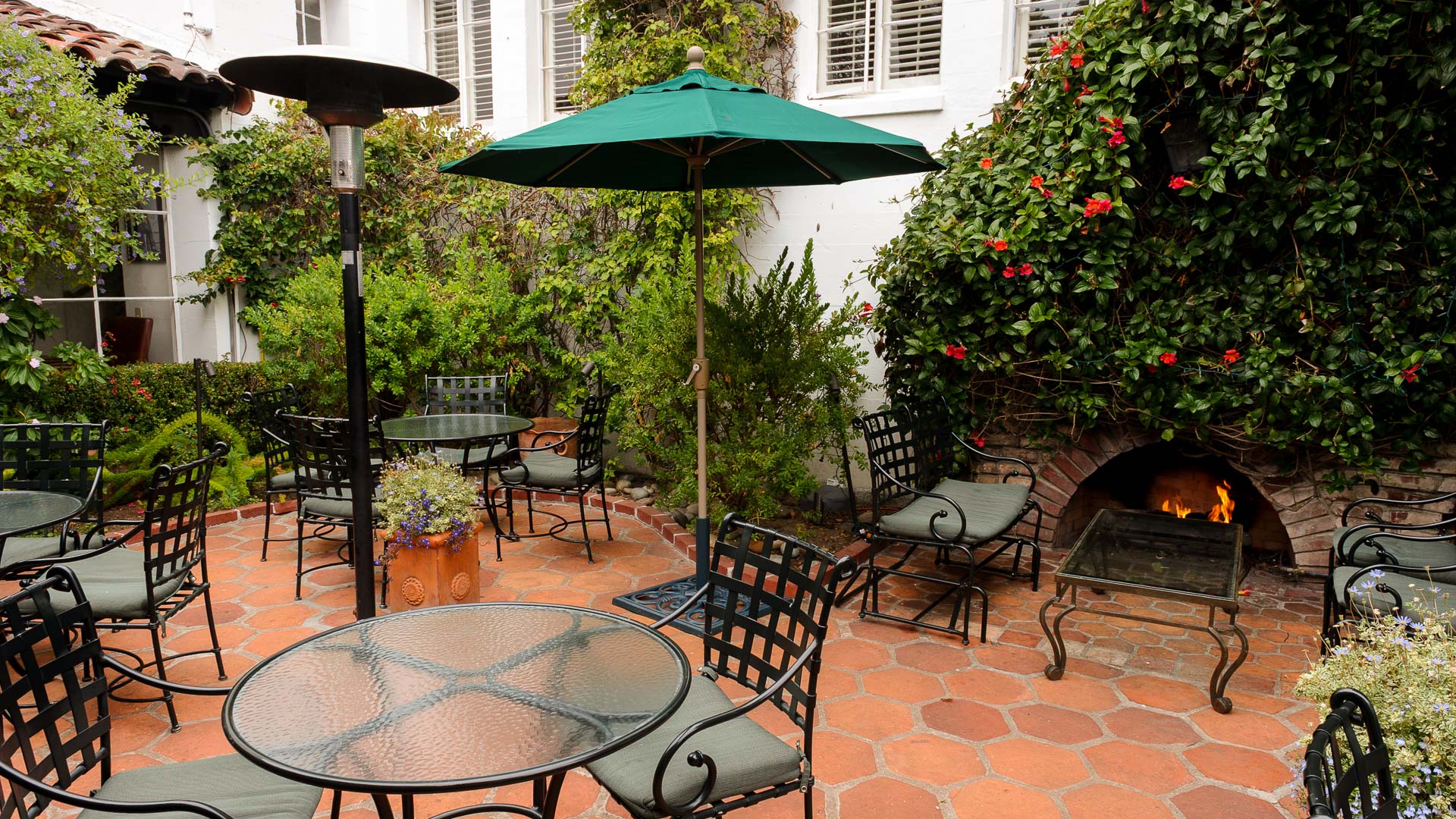 a patio with chairs and umbrella