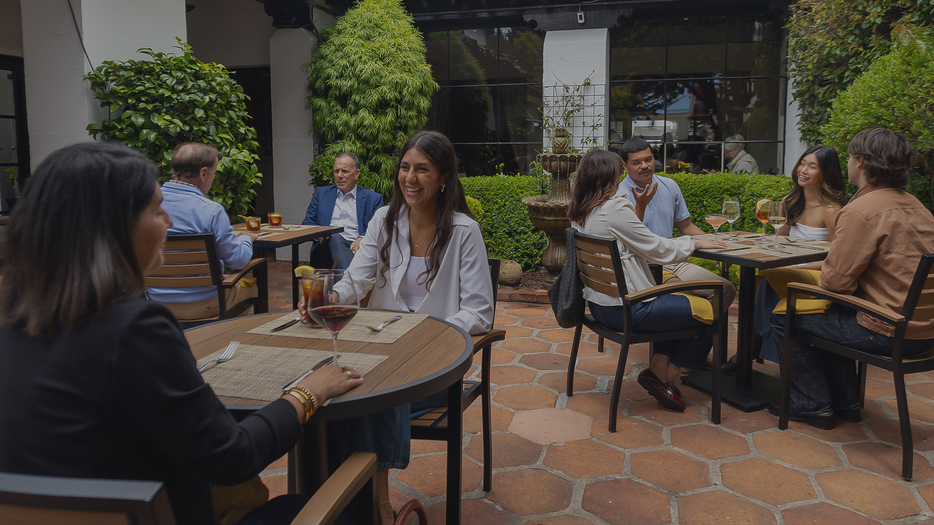 a group of people sitting at tables outside