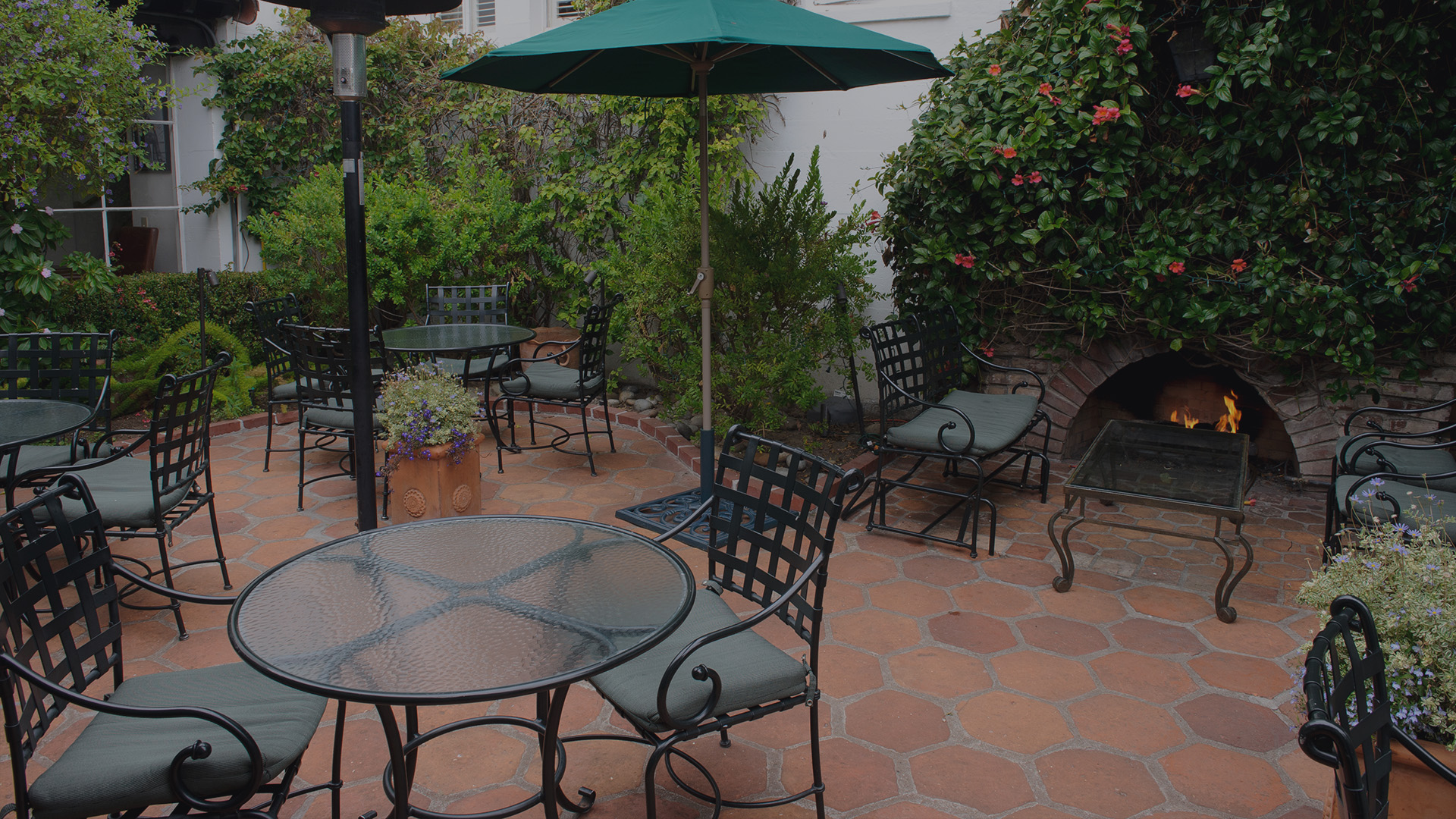a patio with chairs and umbrella