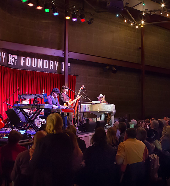 a group of people on a stage with a piano and a keyboard