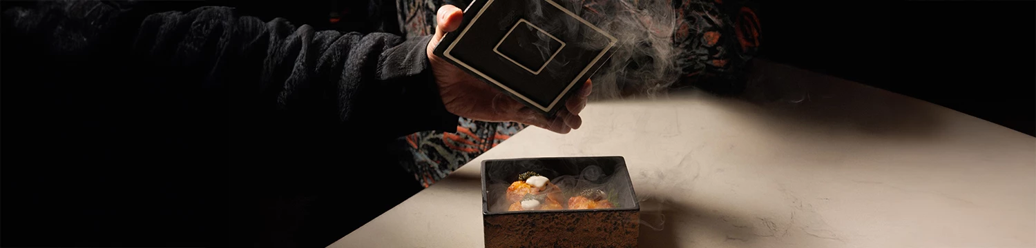 a person holding a square black box with food in it