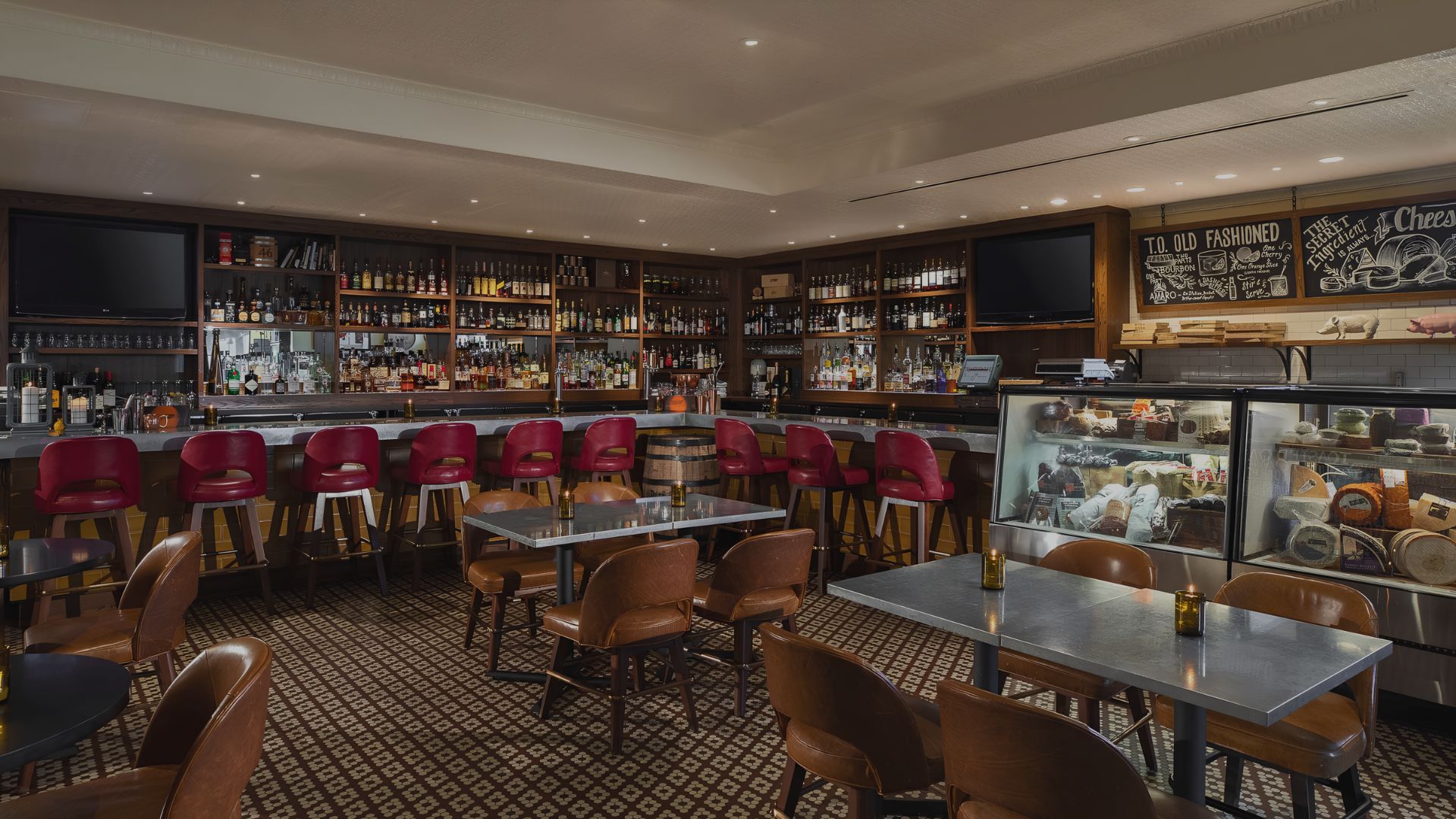 a bar with a variety of bottles and a cooler