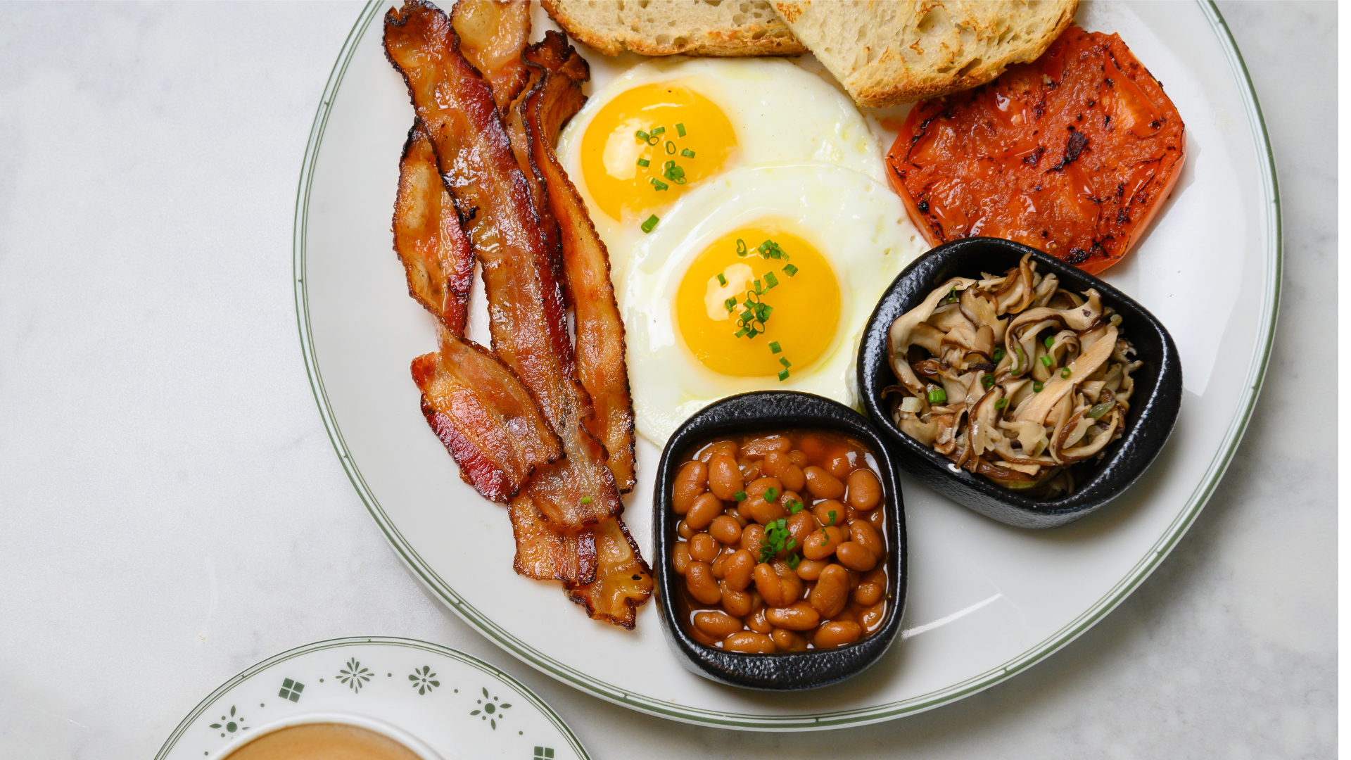 a plate of breakfast with eggs bacon and beans