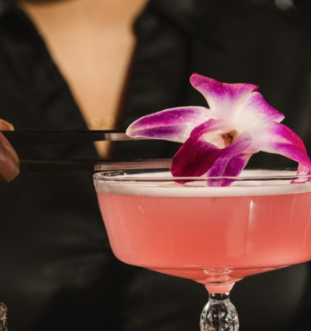 a person holding a drink with a flower on it