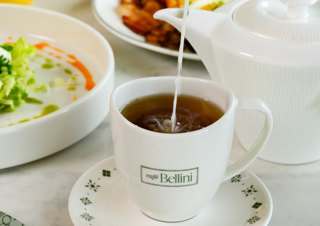 a cup of tea being poured into a cup
