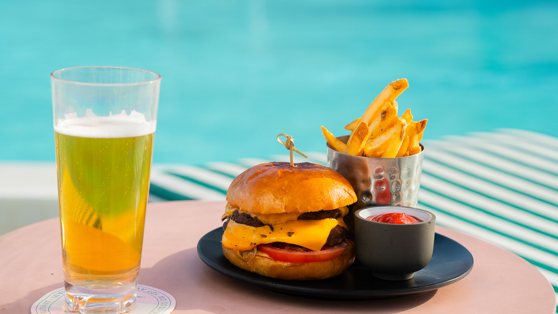 a burger and fries on a plate next to a drink