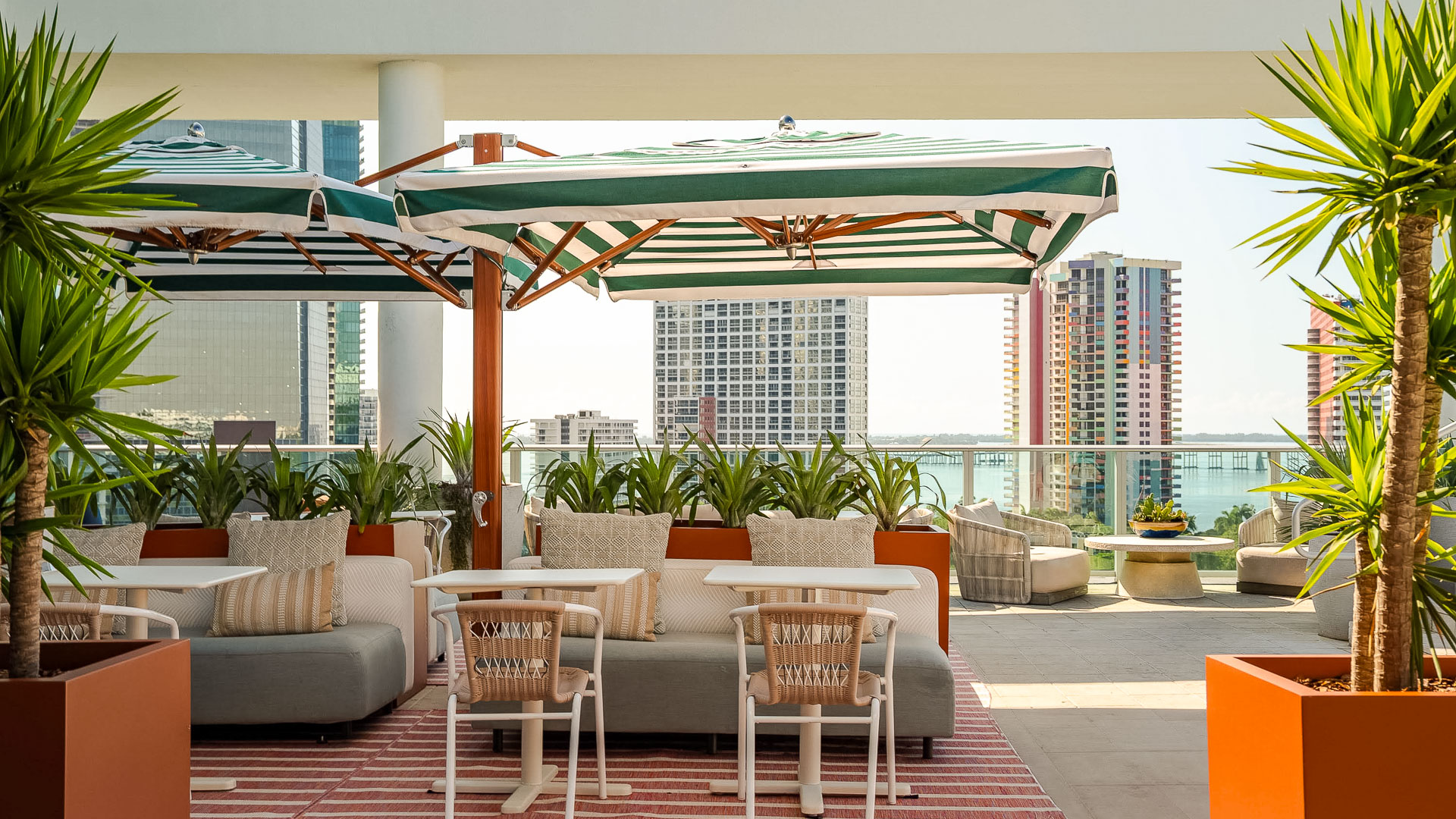 a patio with a striped umbrella and chairs