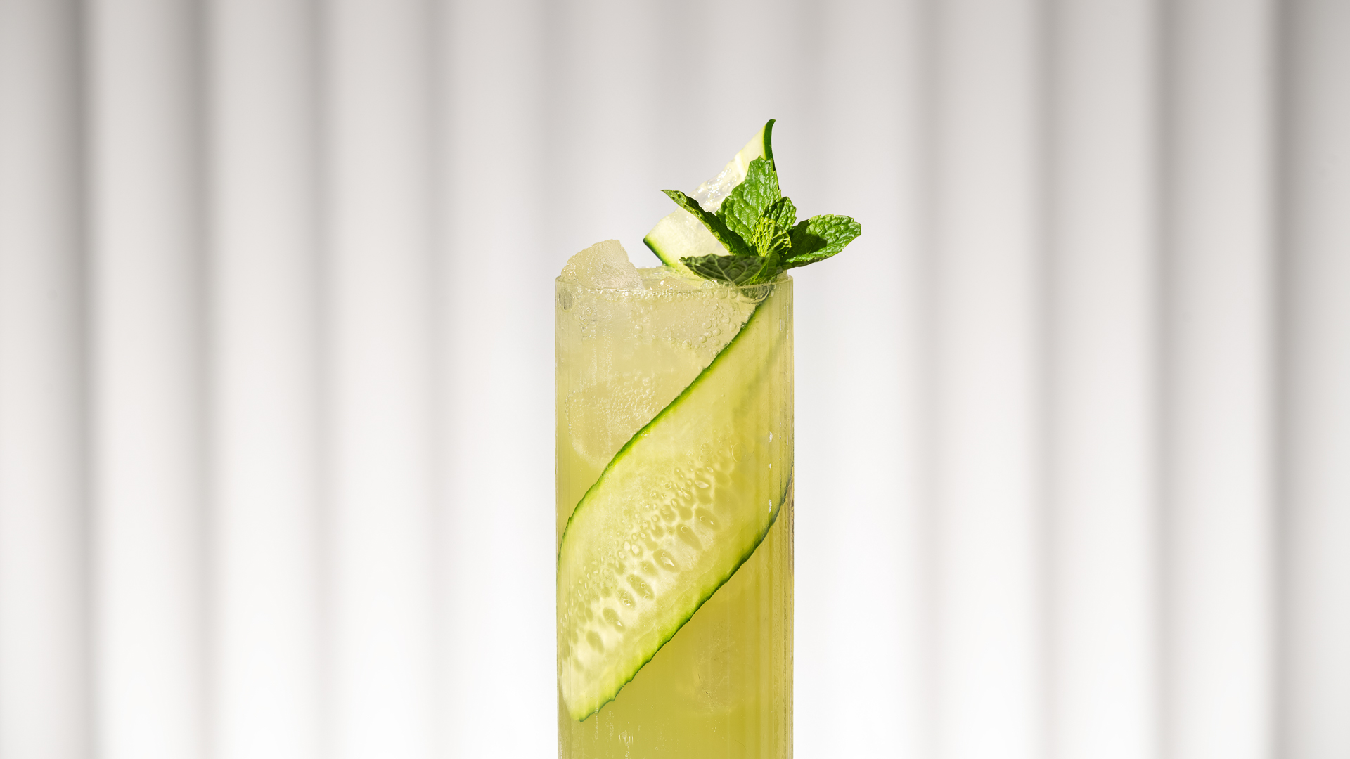a glass with a cucumber and mint on top