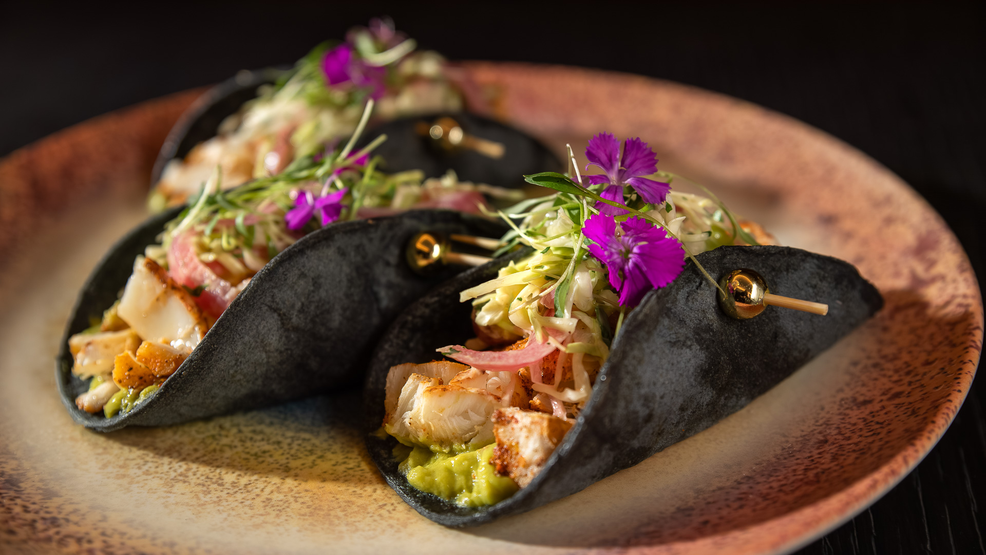 a black taco on a plate