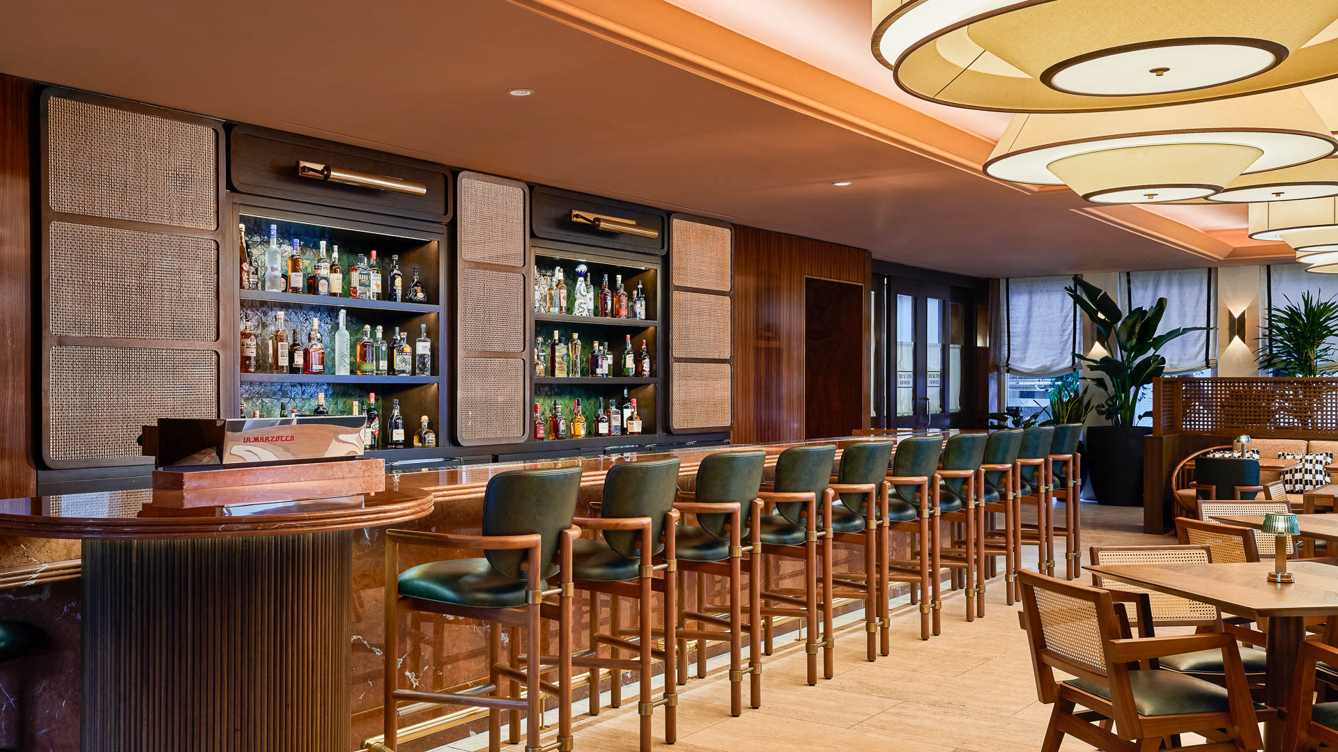 a bar with chairs and shelves of liquor