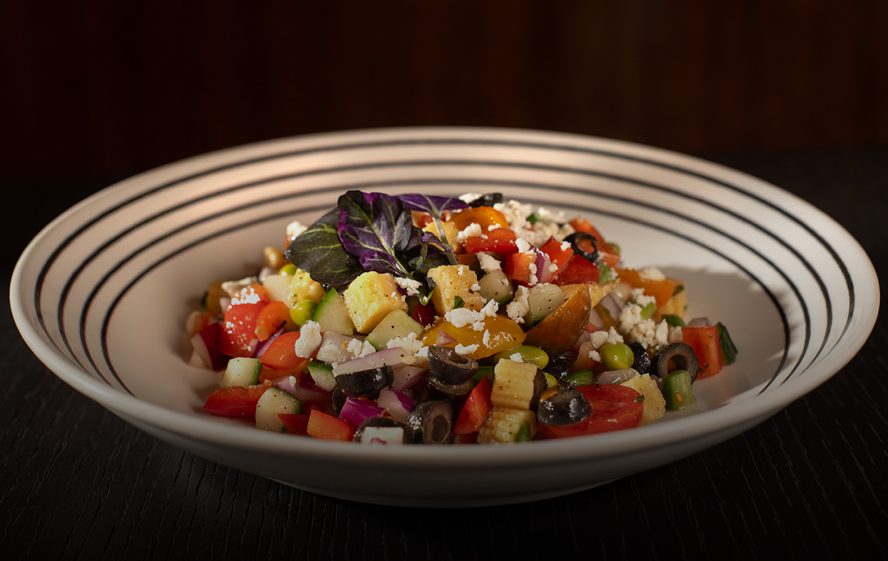 a bowl of salad with vegetables and cheese