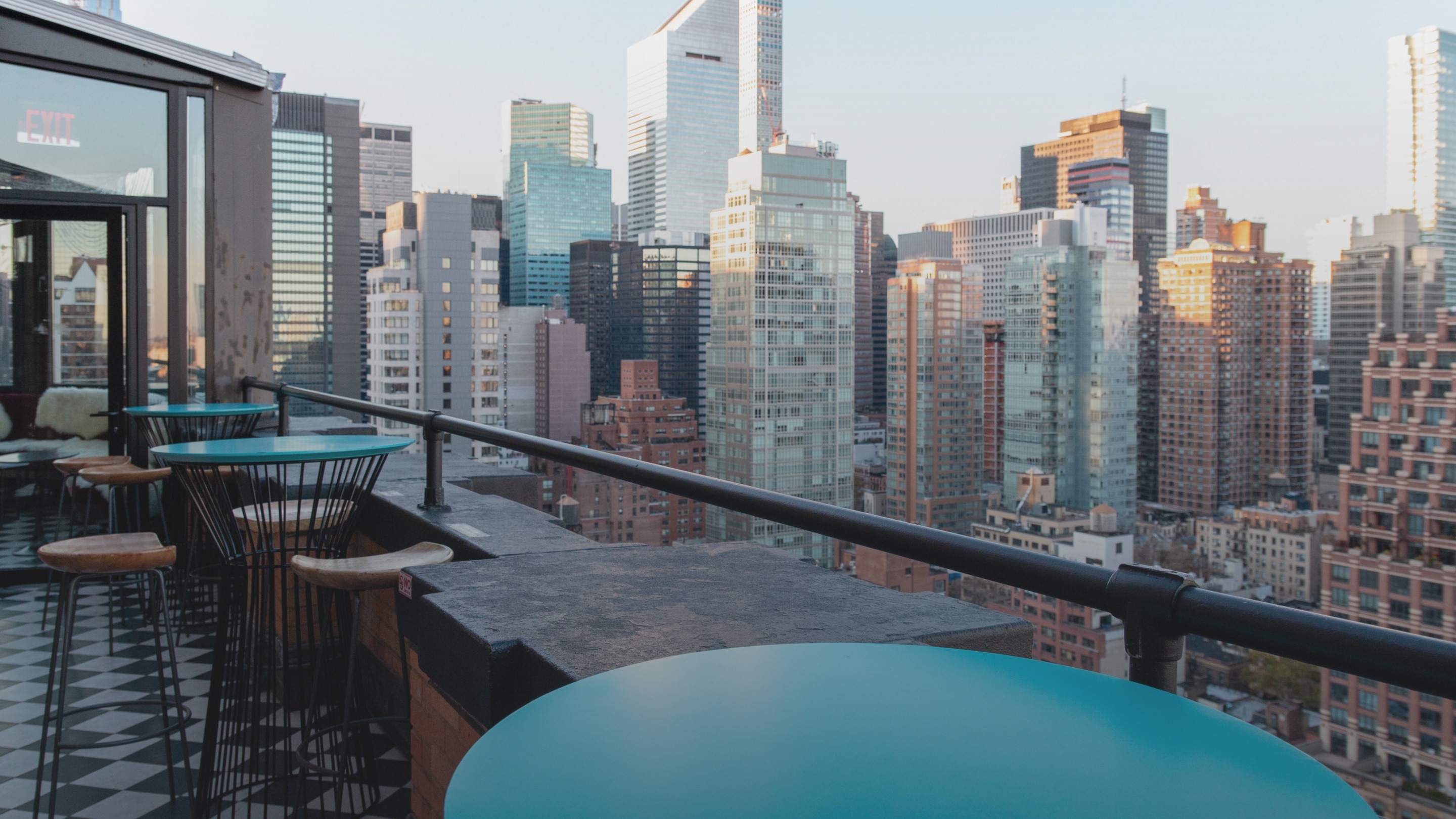 a table and chairs on a rooftop overlooking a city