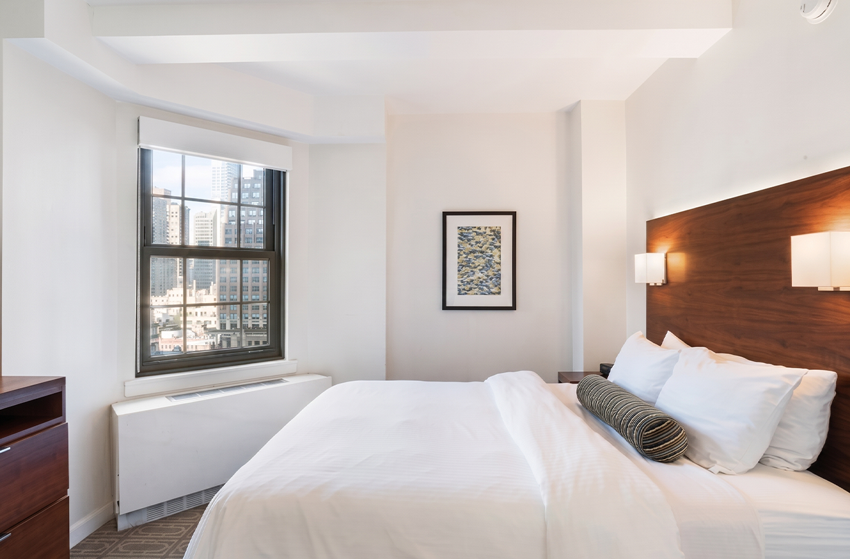 a bed with a window and a picture on the wall