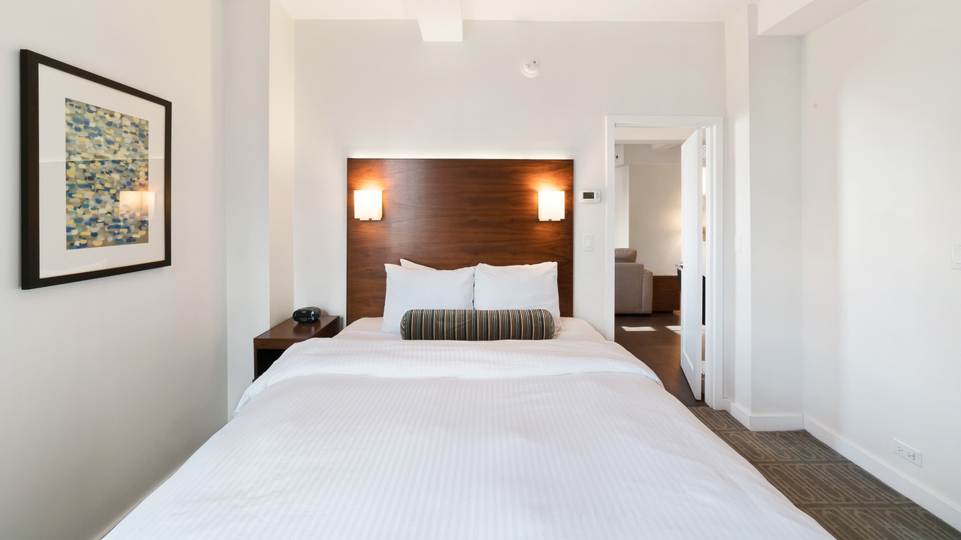 a bed with white sheets and pillows