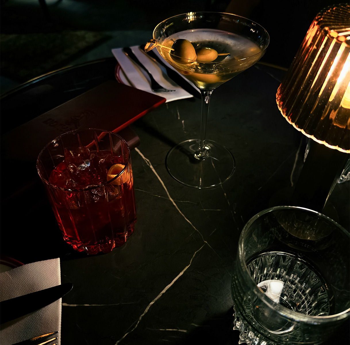a glass of liquid and a lamp on a table