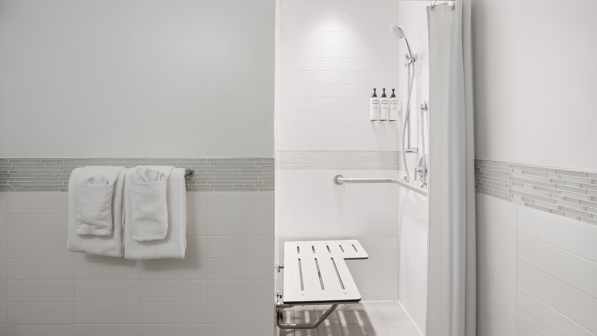a shower with a bench and a shower curtain