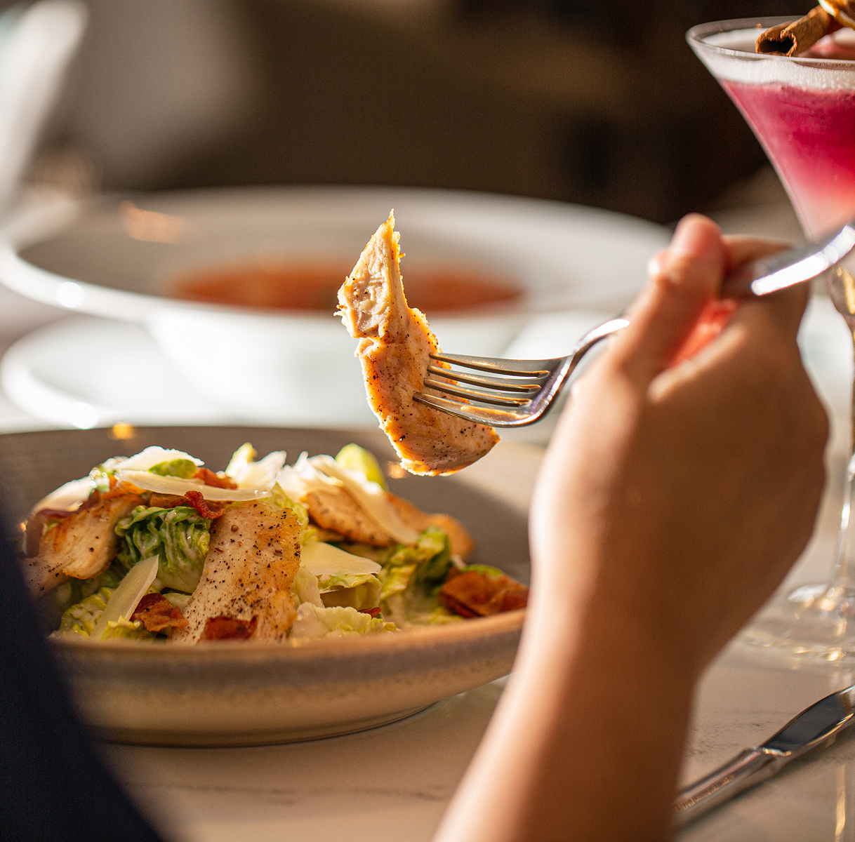 a person holding a fork over a plate of food