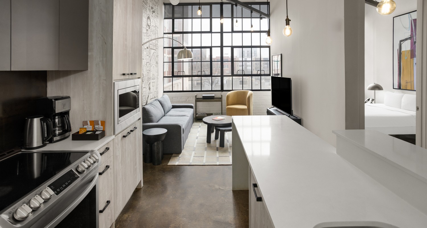 a room with a couch and a kitchen
