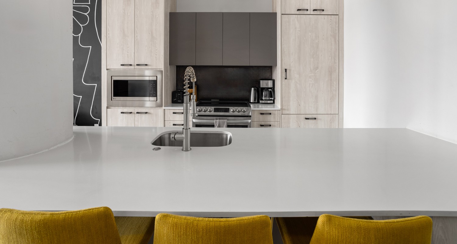 a kitchen with a sink and chairs