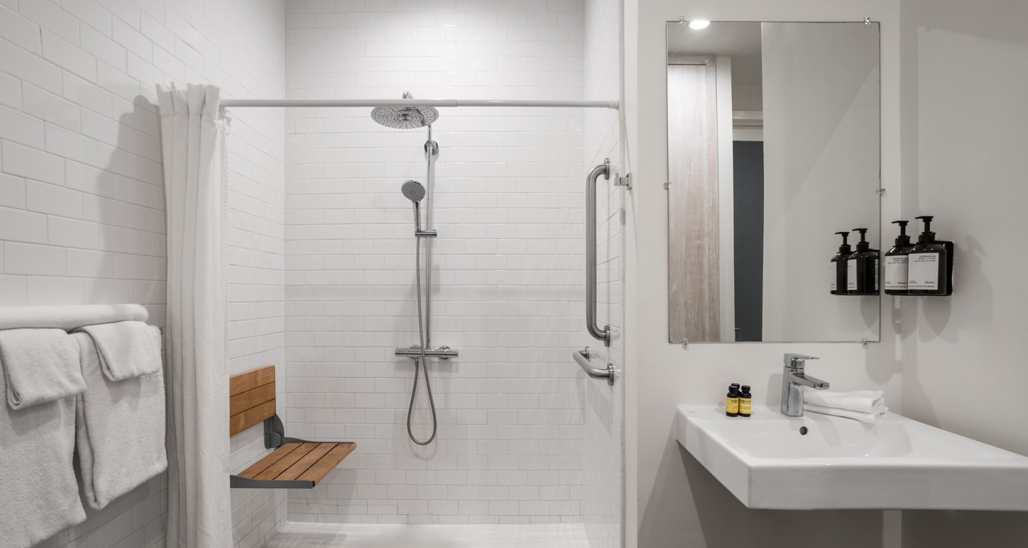 a shower with a bench and sink