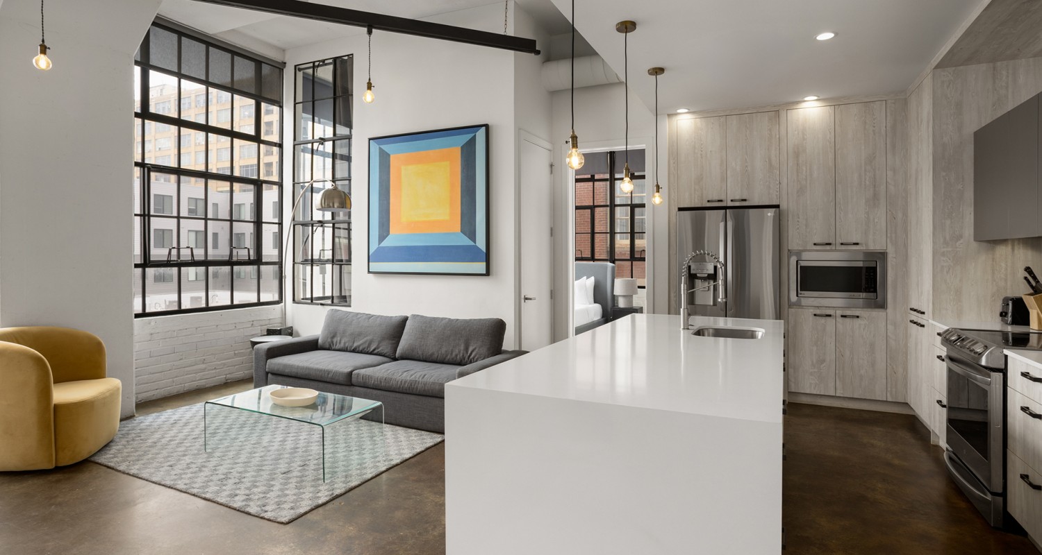 a kitchen and living room with a couch and a refrigerator