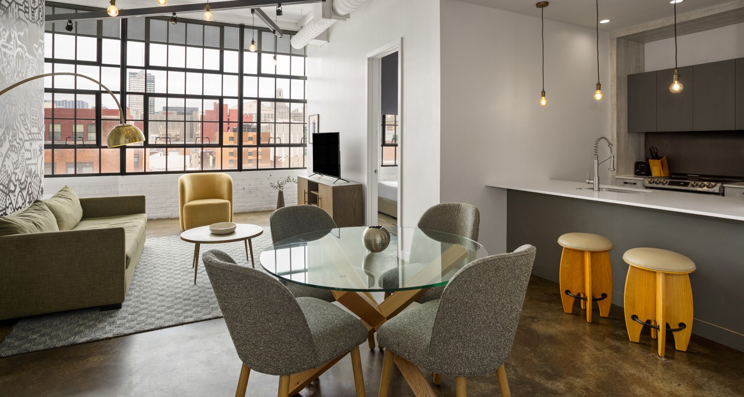 a room with a glass table and chairs