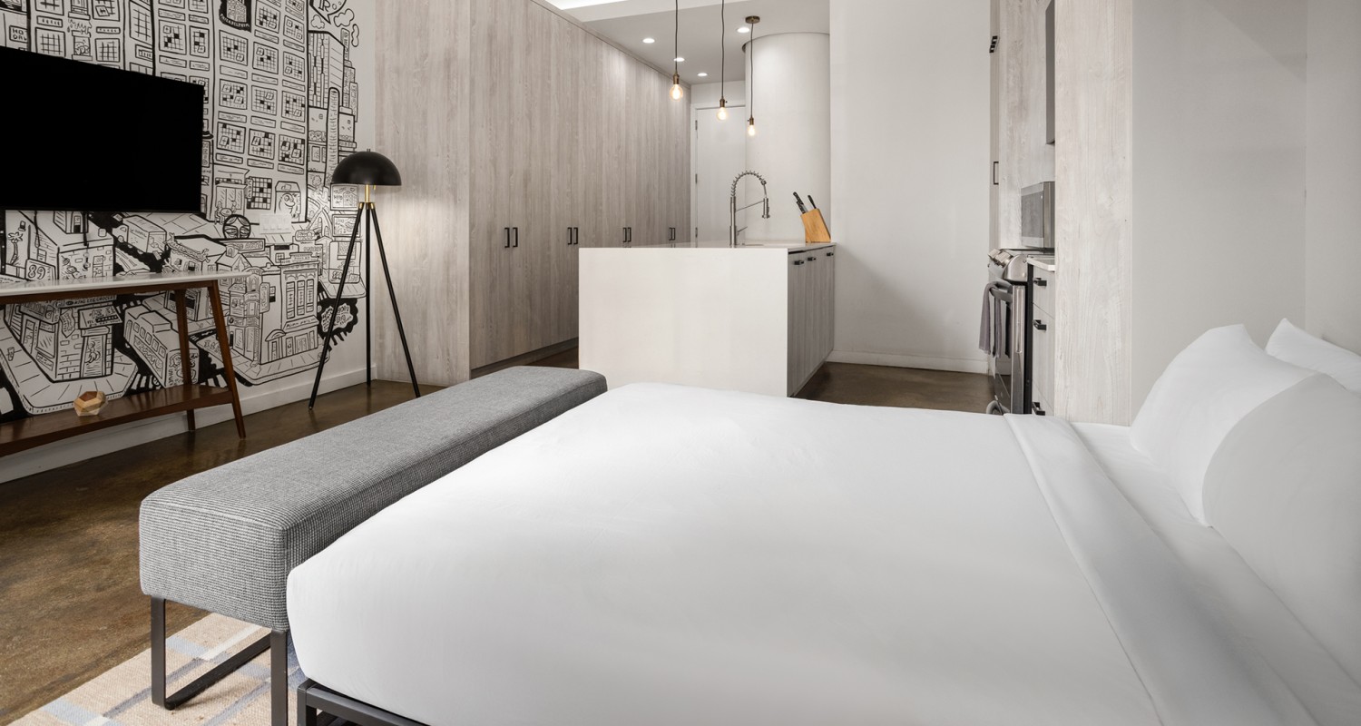 a room with a bed and a kitchen