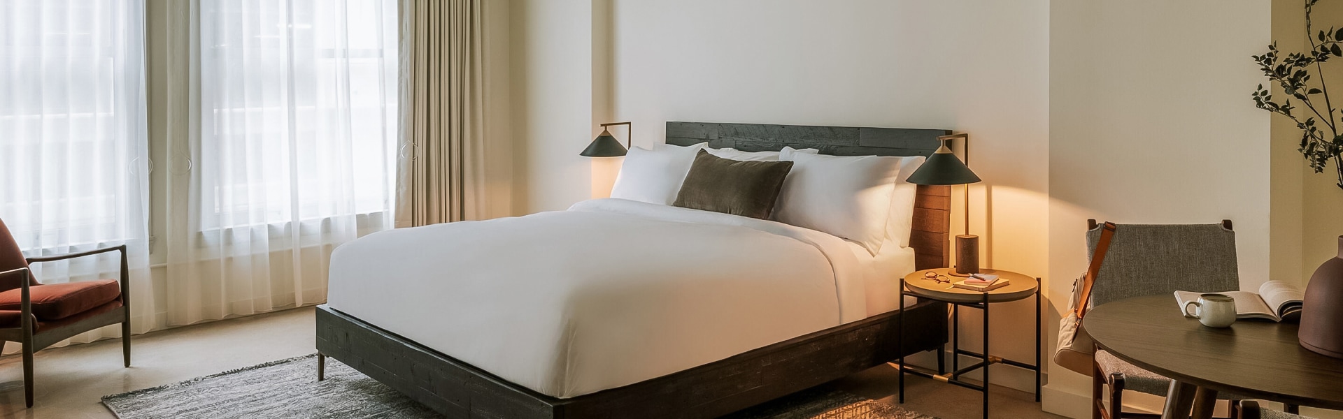 a bed with white sheets and pillows