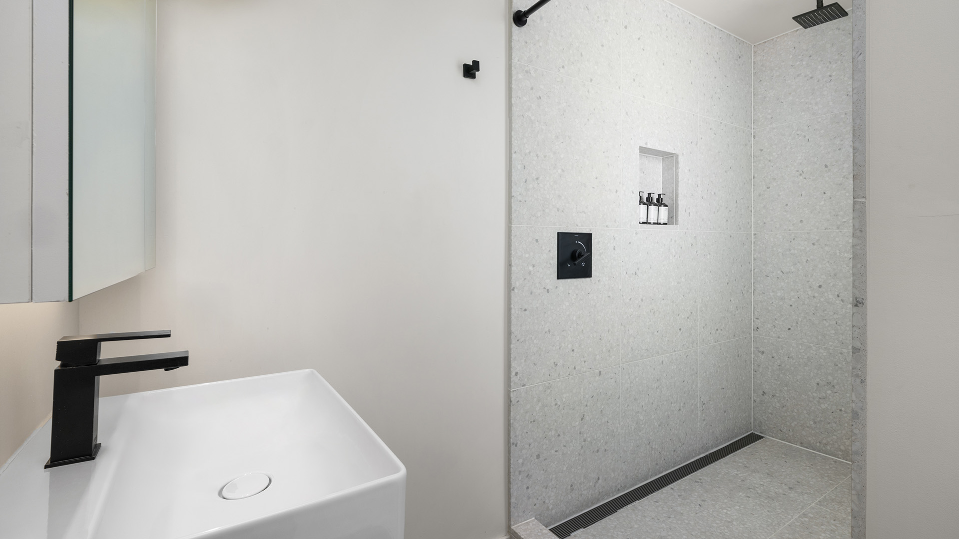 a white bathroom with a sink and shower