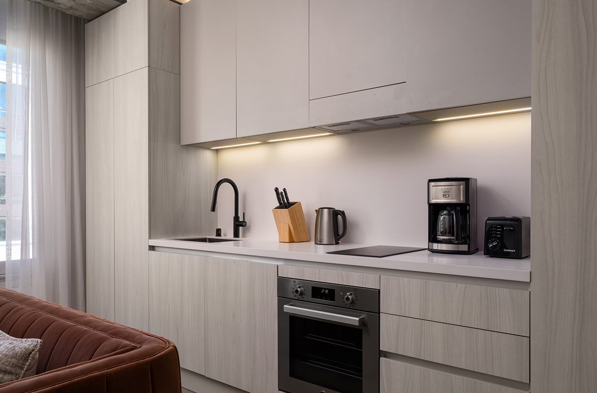 a kitchen with white cabinets and a black faucet