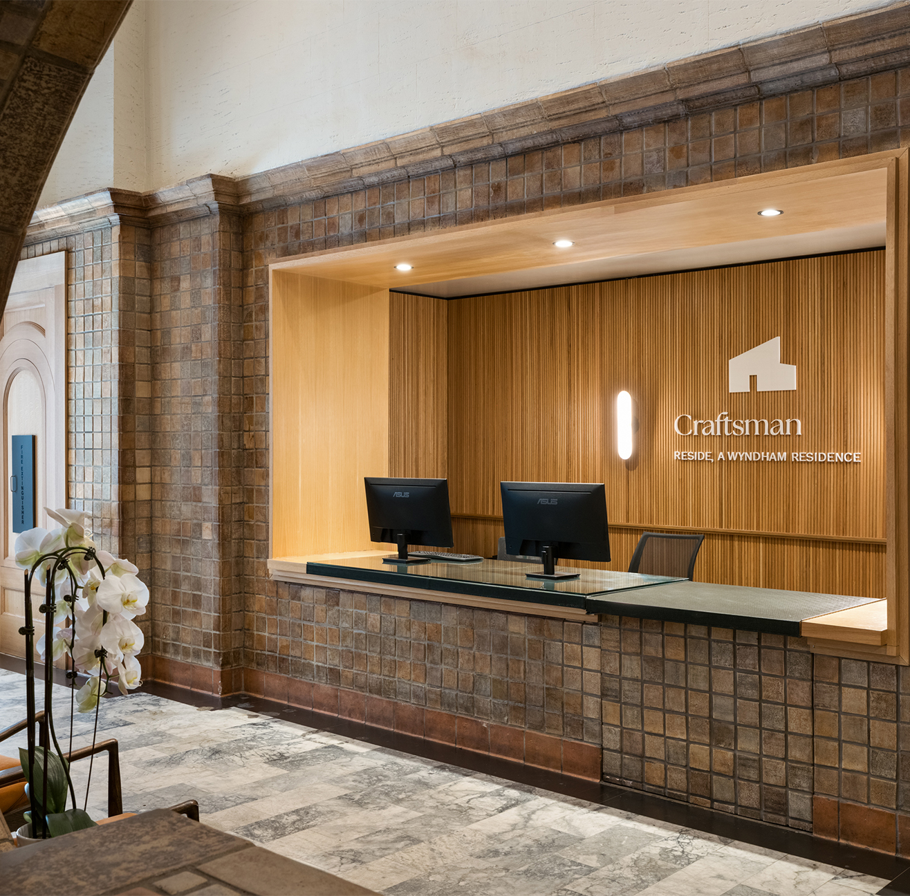 a desk with computers in a brick wall