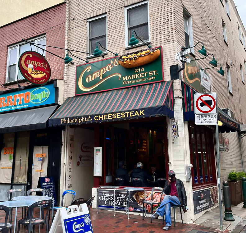 a man sitting at a table outside of a restaurant