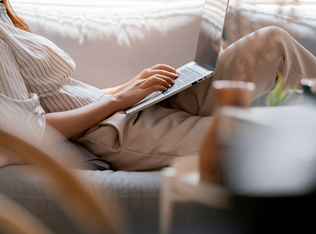 a person sitting on a couch using a laptop