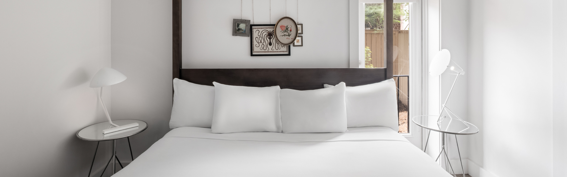 a bed with white sheets and pillows