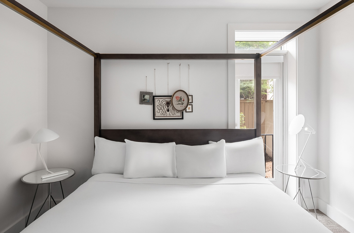 a bed with white sheets and pillows