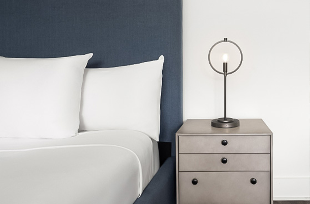 a bed with a lamp on a nightstand