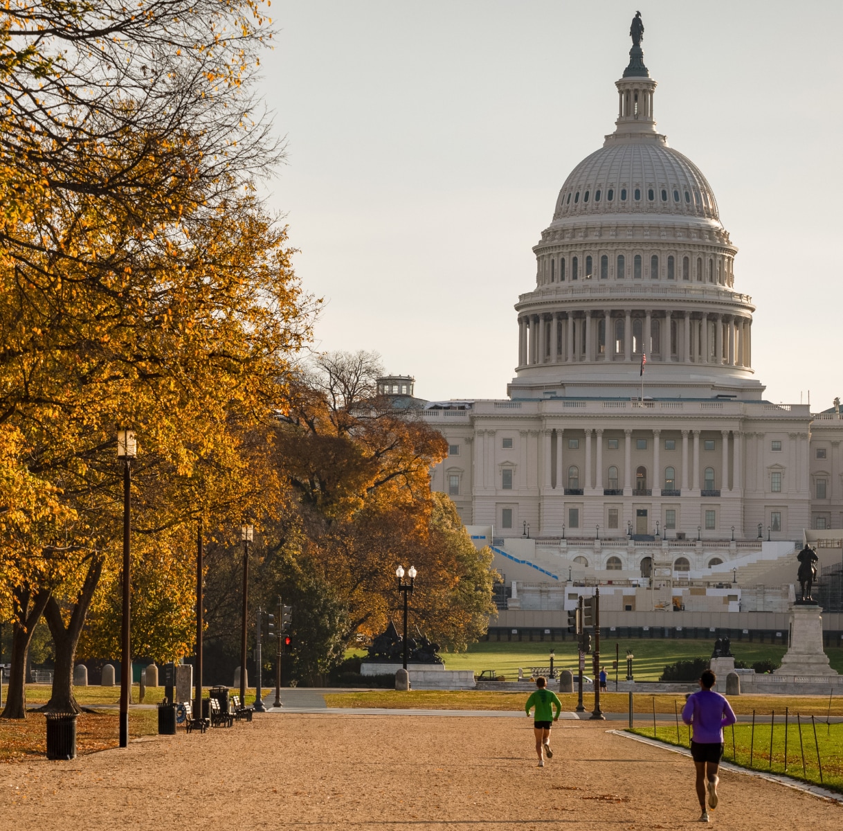 a couple of people running in front of a large white building