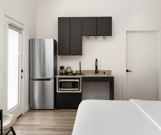 a room with a bed and a refrigerator