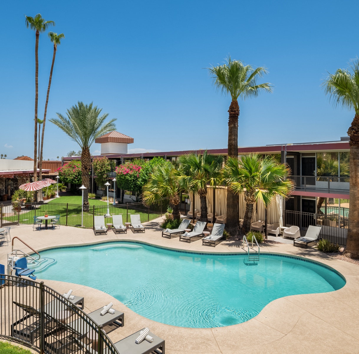 a pool with chairs and a fence around it