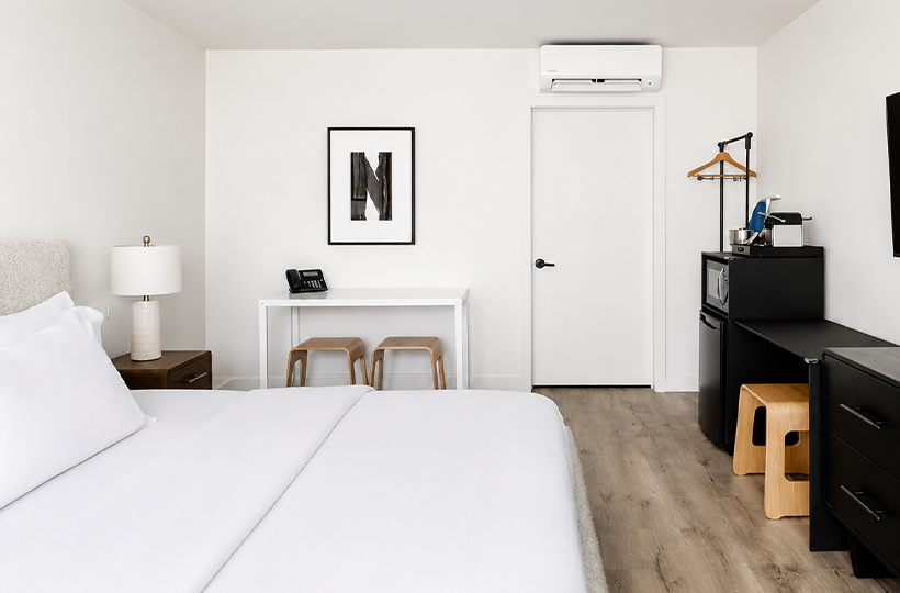 a room with a bed and a refrigerator