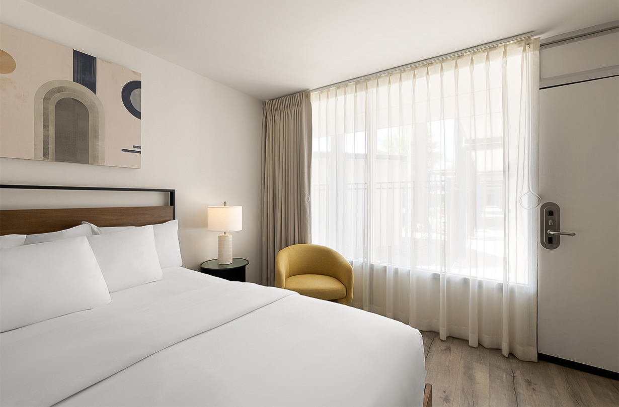 a bed with a lamp and a chair in a room