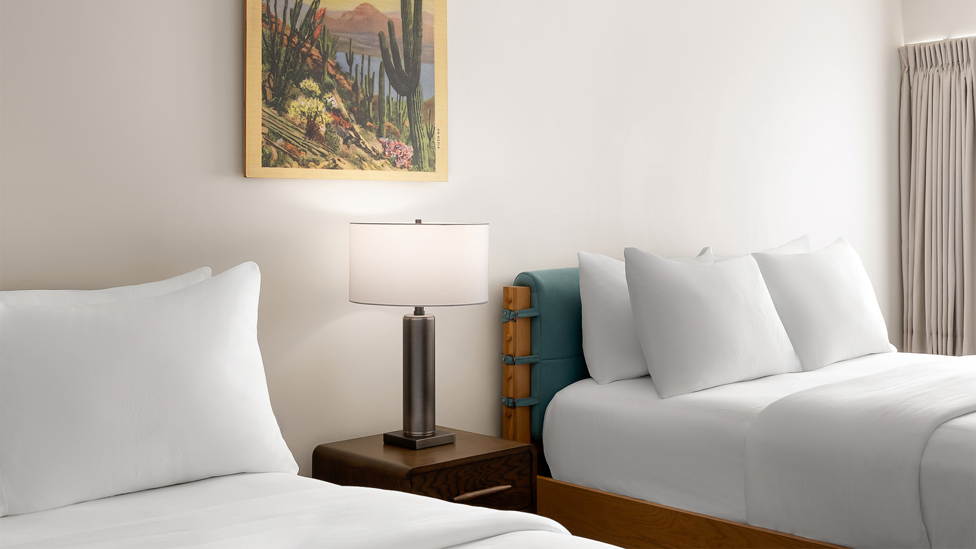 a bed with pillows and a lamp on a nightstand